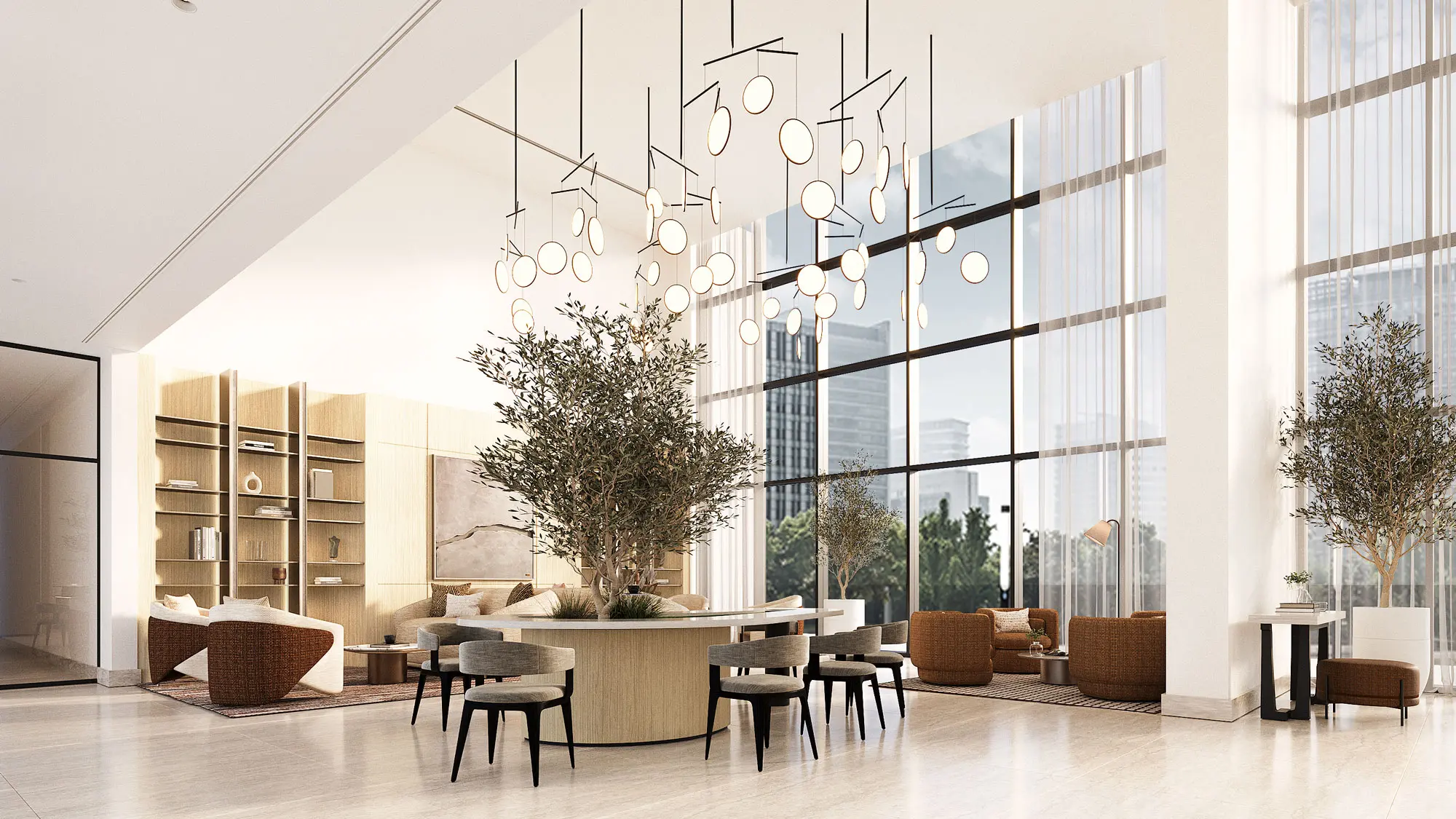 Double-height arrival lobby with a cluster chandelier, olive trees and a circular reception desk